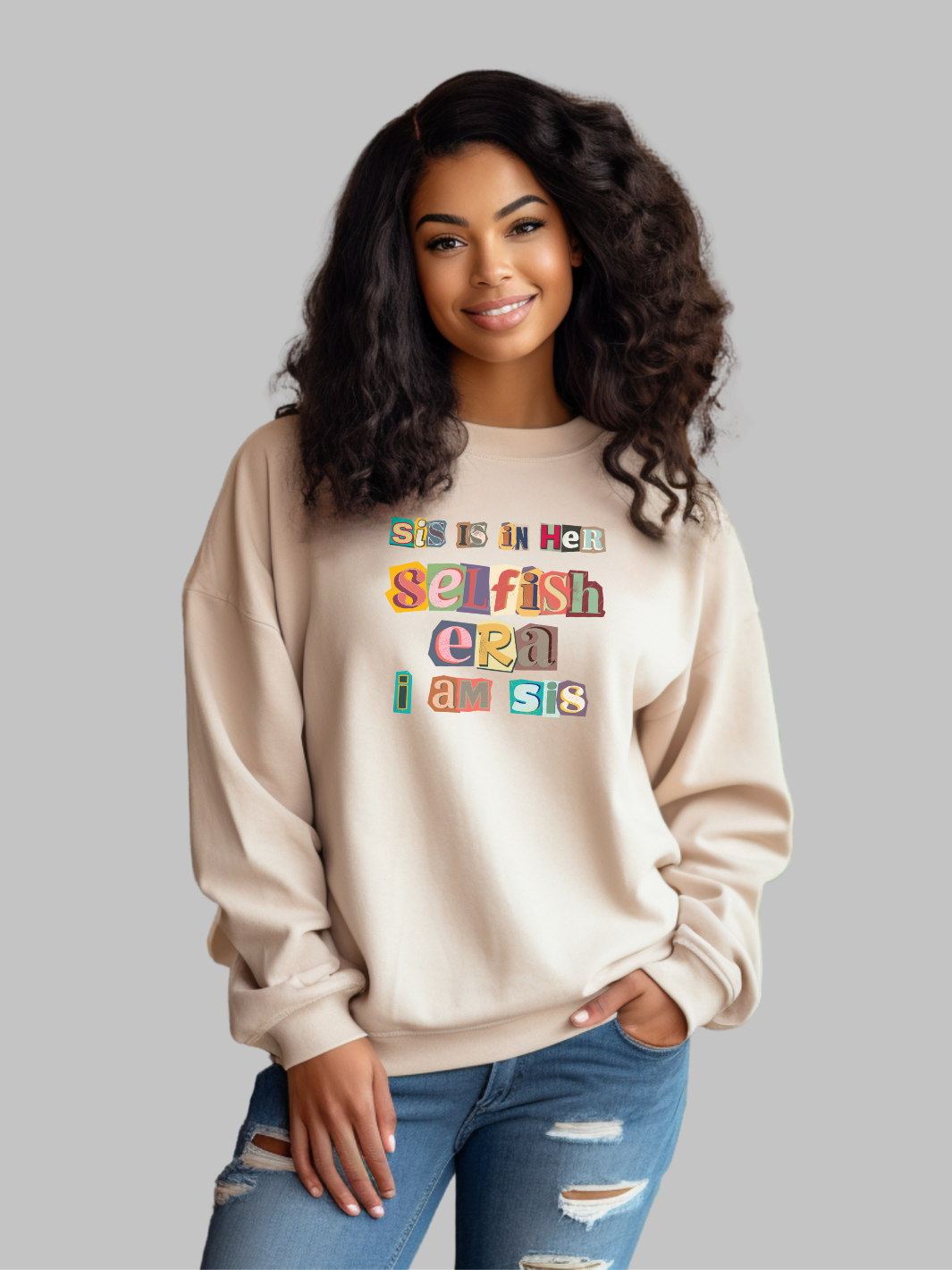 Image of a tan-colored crewneck sweatshirt featuring the phrase 'Sis in her Selfish era. I am Sis' in a unique, multicolored ripped paper font. The text, appearing as if it's made from torn pieces of paper in various colors, creates a dynamic and artistic effect against the neutral tan background. This design conveys a message of self-empowerment and individuality, with the playful and creative font adding a touch of whimsy and boldness to the statement. self love sweatshirt , self care crew neck sweatshirt