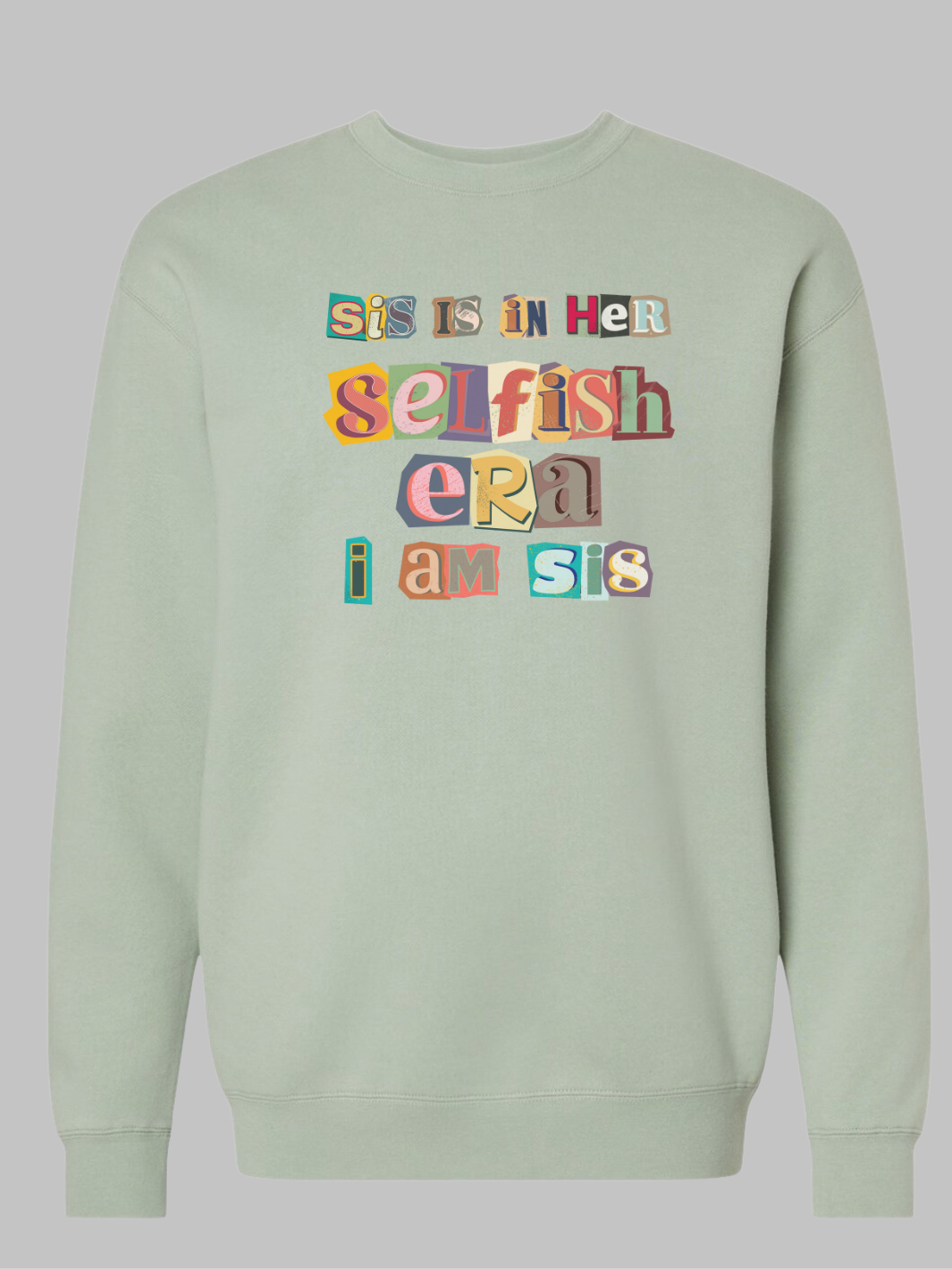 Image of a sage green -colored crewneck sweatshirt featuring the phrase 'Sis in her Selfish era. I am Sis' in a unique, multicolored ripped paper font. The text, appearing as if it's made from torn pieces of paper in various colors, creates a dynamic and artistic effect against the neutral tan background. This design conveys a message of self-empowerment and individuality, with the playful and creative font adding a touch of whimsy and boldness to the statement. Self love sweatshirt. self care sweatshirt